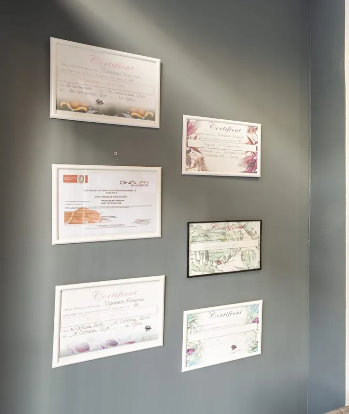 Six certificats de formation encadrés sur le mur ardoise du salon