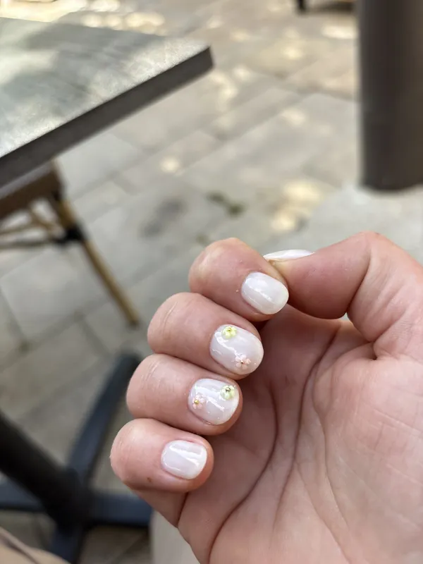 Ongles courts rose pâle, petites fleurs blanches et dorées