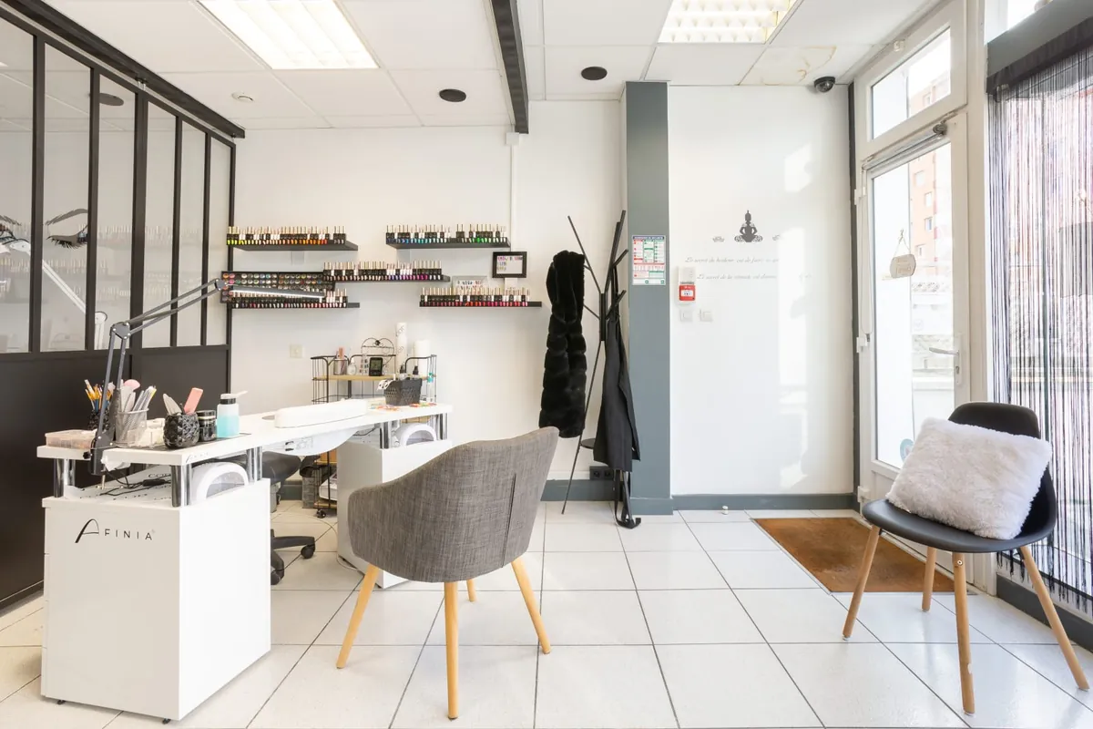Le poste ongles, vernis rangés sur des étagères au mur
